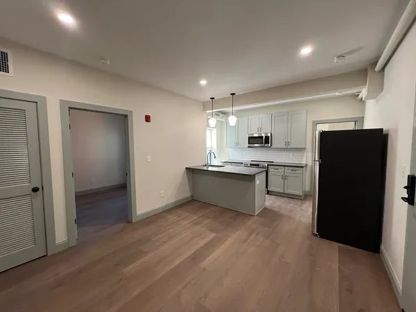 a kitchen with a refrigerator and a stove top oven