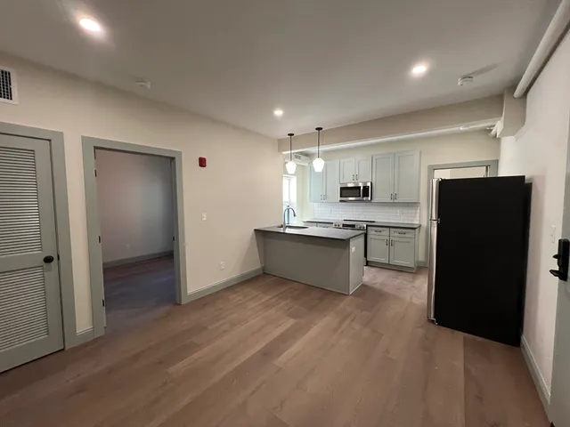 a kitchen with a refrigerator and a stove top oven