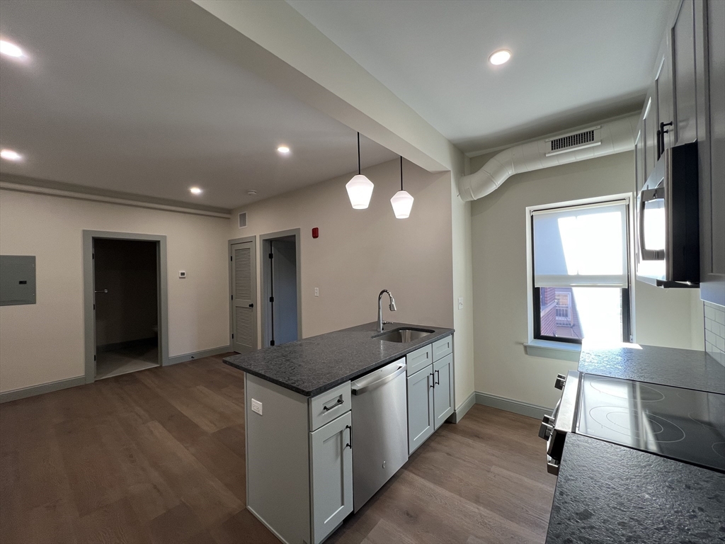 160 Seabury Street, Unit 13 Fall River, MA 02720 - Photo 3 of 8 a kitchen that has a lot of cabinets and wooden floor