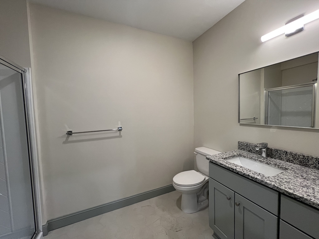160 Seabury Street, Unit 13 Fall River, MA 02720 - Photo 6 of 8 a bathroom with a granite countertop toilet and sink