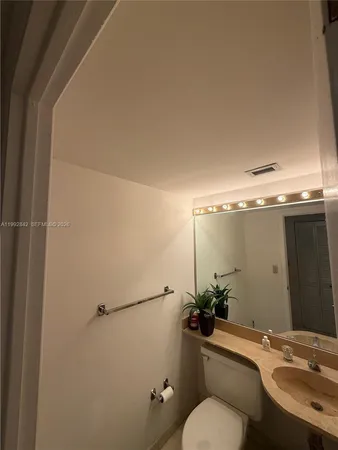 a bathroom with a toilet a sink and mirror
