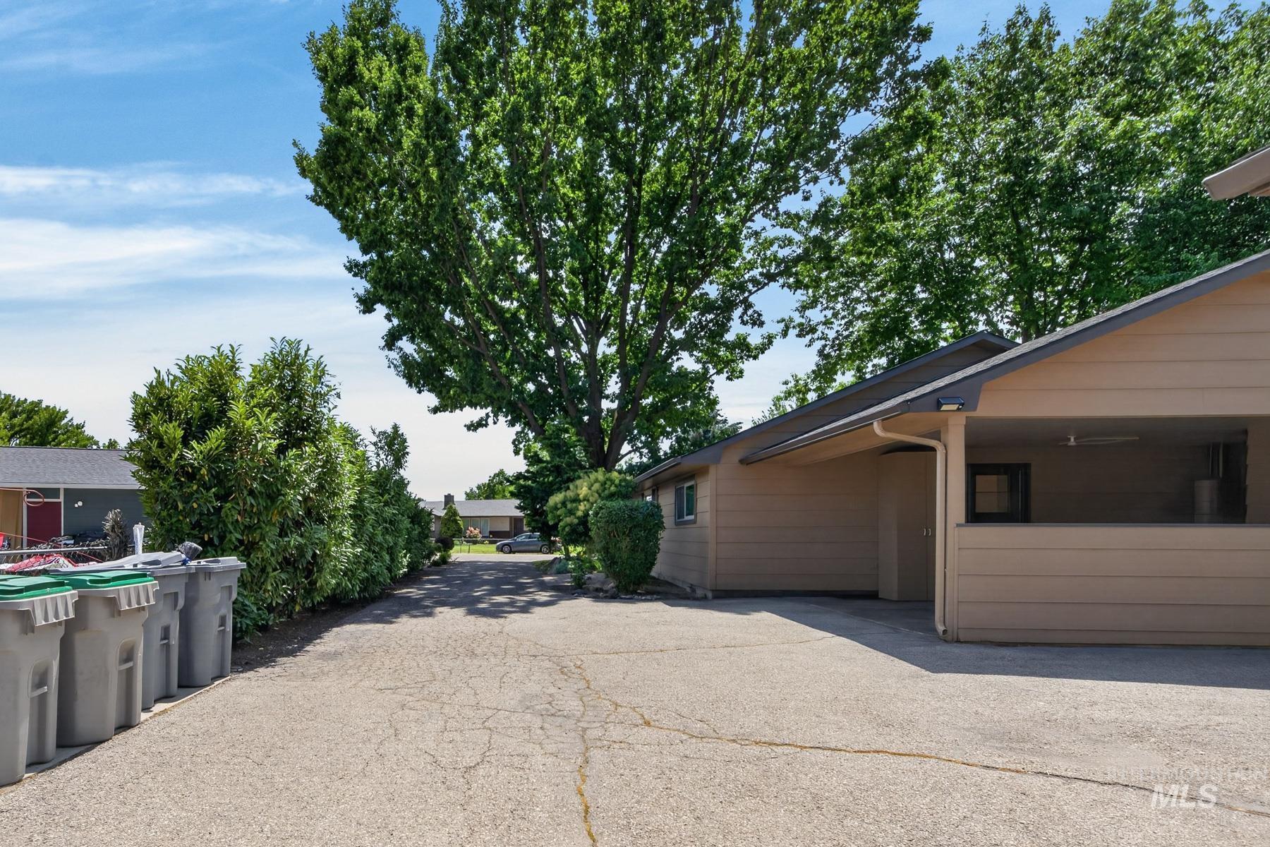 9622 Delaware Street Boise, ID 83709 - Photo 48 of 48 Exterior featuring tan siding, a dark roofline, and a carport with an exposed beam ceiling