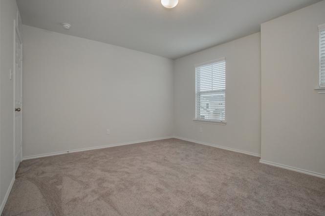 148 Spotted Rail Ridge Leander, TX 78641 - Photo 24 of 31 An inviting secondary bedroom offers soft carpeting and ample natural illumination.