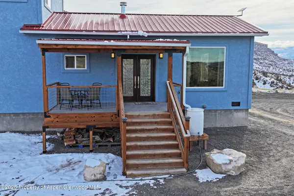 a view of a porch with a table and chairs