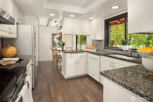 a kitchen with a sink stainless steel appliances and window