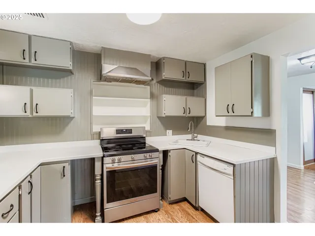 a kitchen with granite countertop a stove sink and cabinets