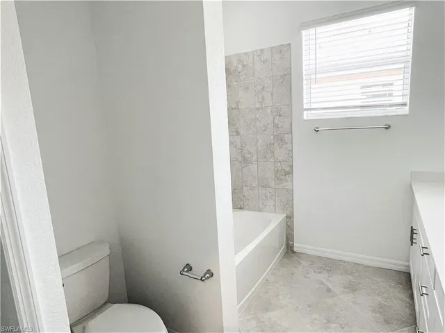a white bath tub sitting next to a toilet