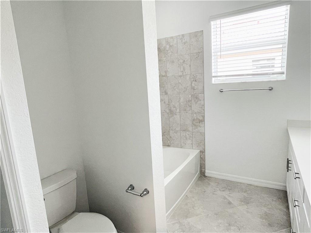 2775 Blossom Way Naples, FL 34120 - Photo 11 of 16 a white bath tub sitting next to a toilet