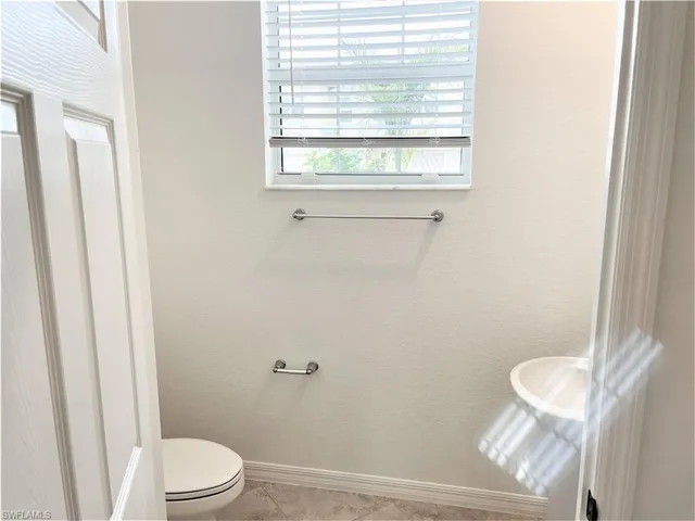 a white toilet sitting next to a window
