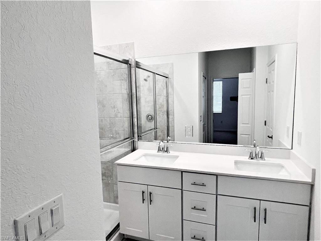 2775 Blossom Way Naples, FL 34120 - Photo 9 of 16 a bathroom with a sink and a mirror