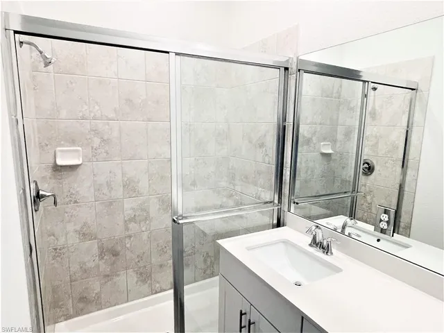 a bathroom with a shower sink and a mirror