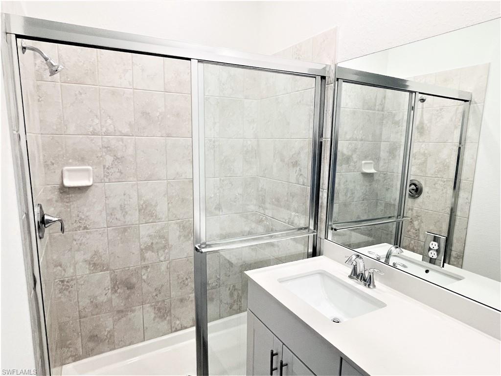 2775 Blossom Way Naples, FL 34120 - Photo 10 of 16 a bathroom with a shower sink and a mirror