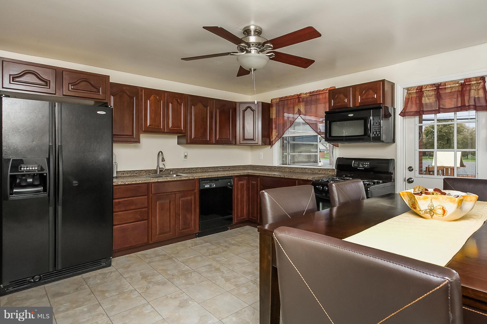 716 Aldworth Road Baltimore, MD 21222 - Photo 1 of 29 a kitchen with stainless steel appliances granite countertop a refrigerator a sink dishwasher a dining table and chairs with wooden floor