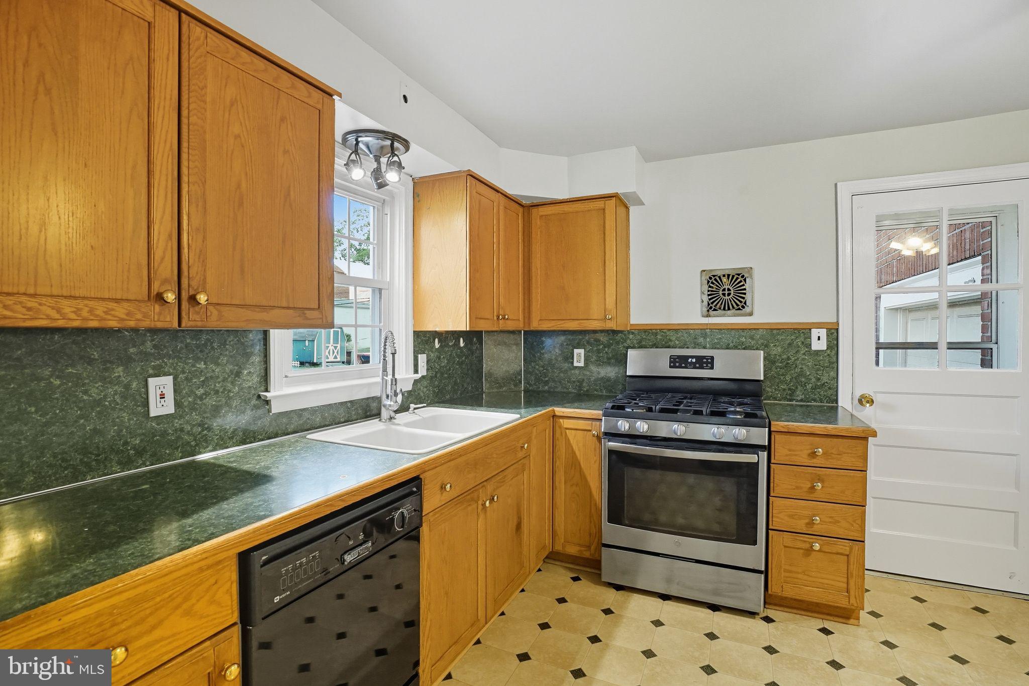 979 Edgewood Drive Springfield, PA 19064 - Photo 12 of 36 a kitchen with granite countertop a sink a stove and cabinets