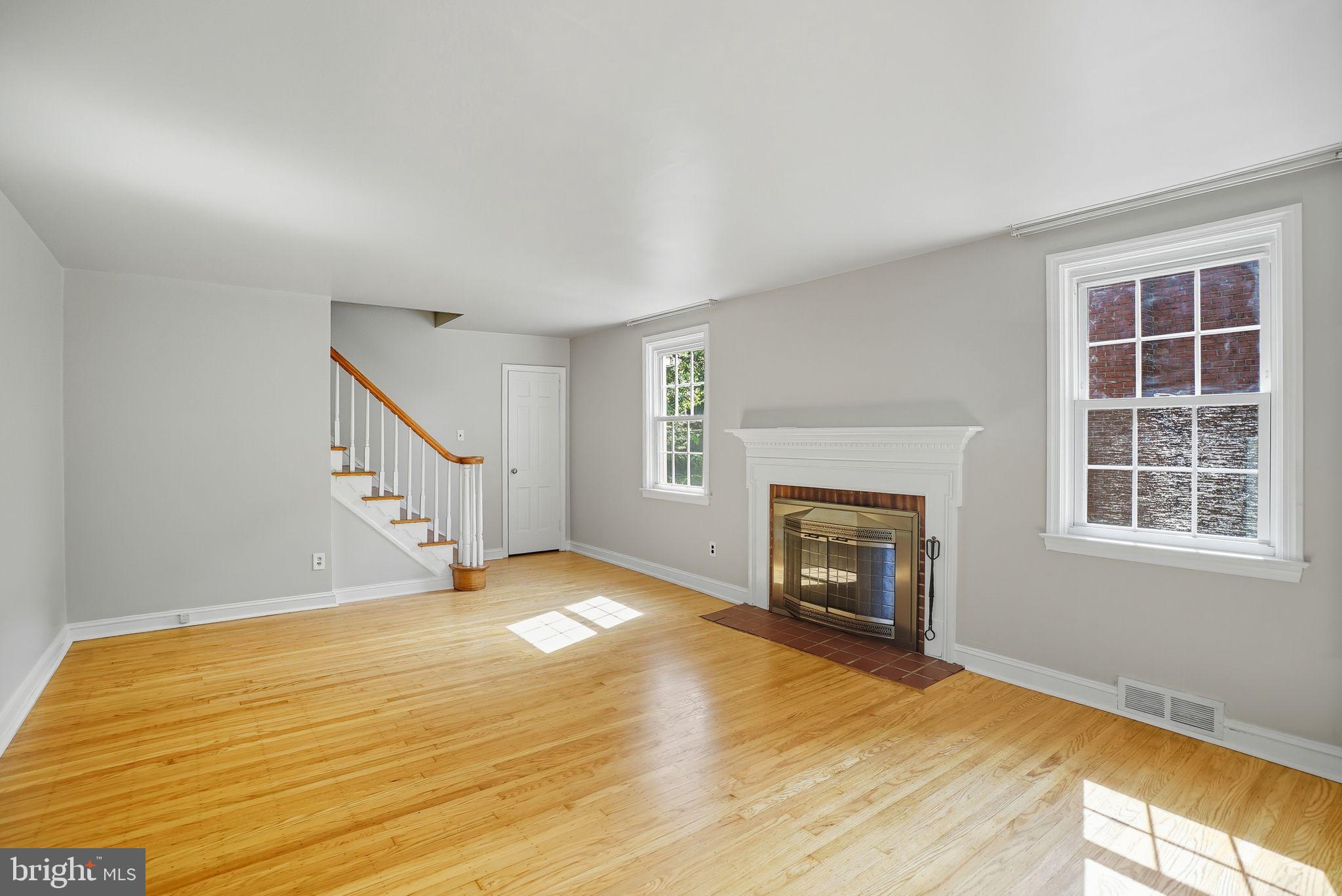 979 Edgewood Drive Springfield, PA 19064 - Photo 5 of 36 a view of an empty room with wooden floor fireplace and a window
