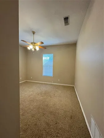en empty room with windows and chandelier
