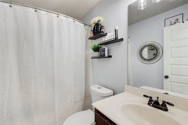 a bathroom with a sink a toilet and a mirror