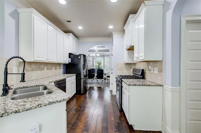 a kitchen with a sink stove top oven and refrigerator