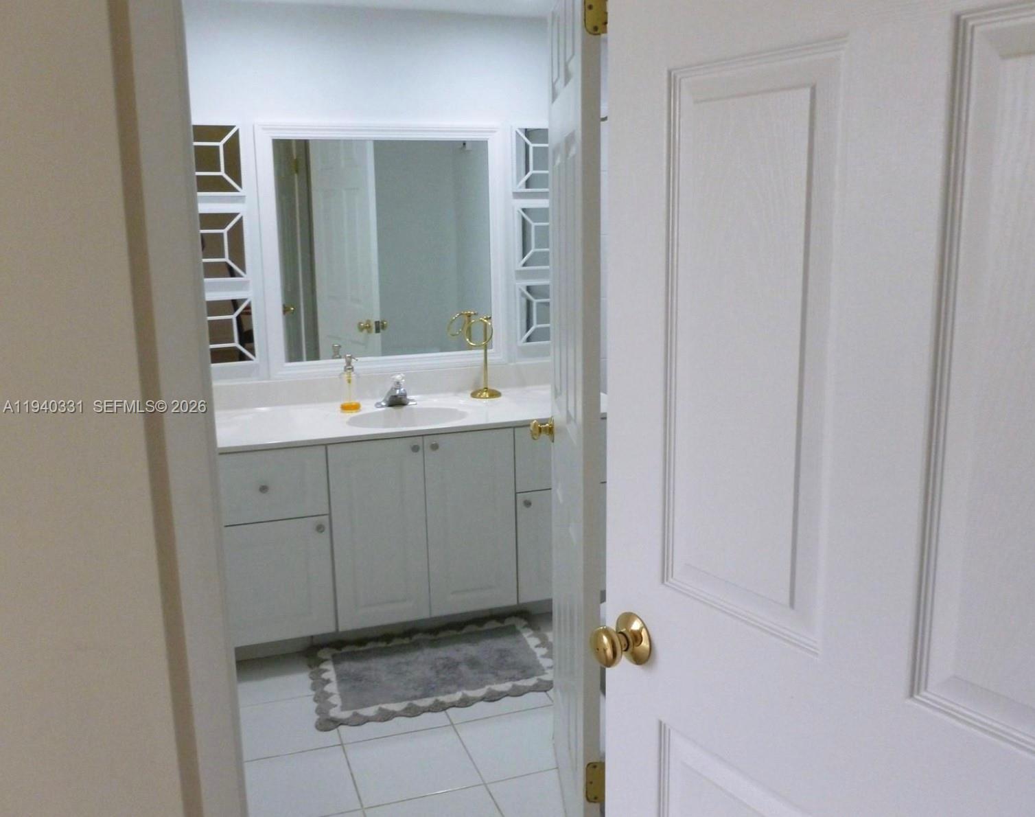 16300 Golf Club Road, Unit 203 Weston, FL 33326 - Photo 5 of 11 a bathroom with a sink and mirror