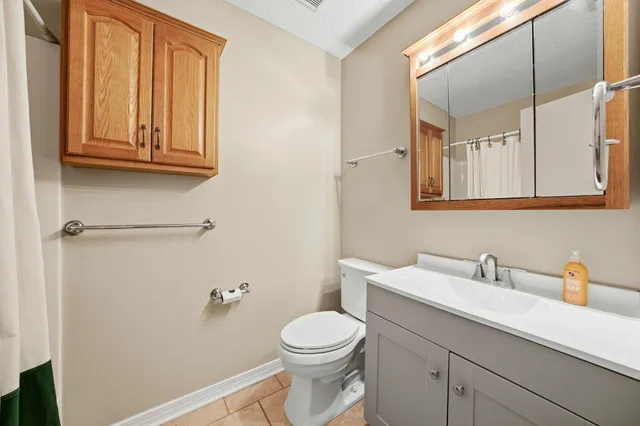 a view of a hallway with wooden floor and a bathroom