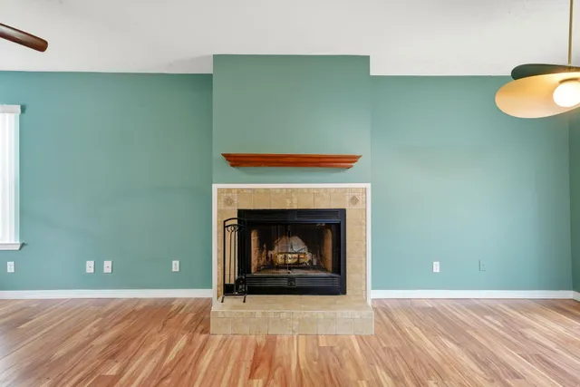a living room with a fireplace and wooden floor