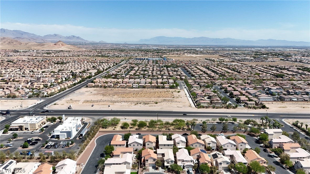 8934 Deep Ridge Court Las Vegas, NV 89178 - Photo 42 of 47 Vast desert landscape with a residential community, roads, and distant mountains under a clear sky.