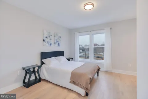 a bedroom with a bed and a large window