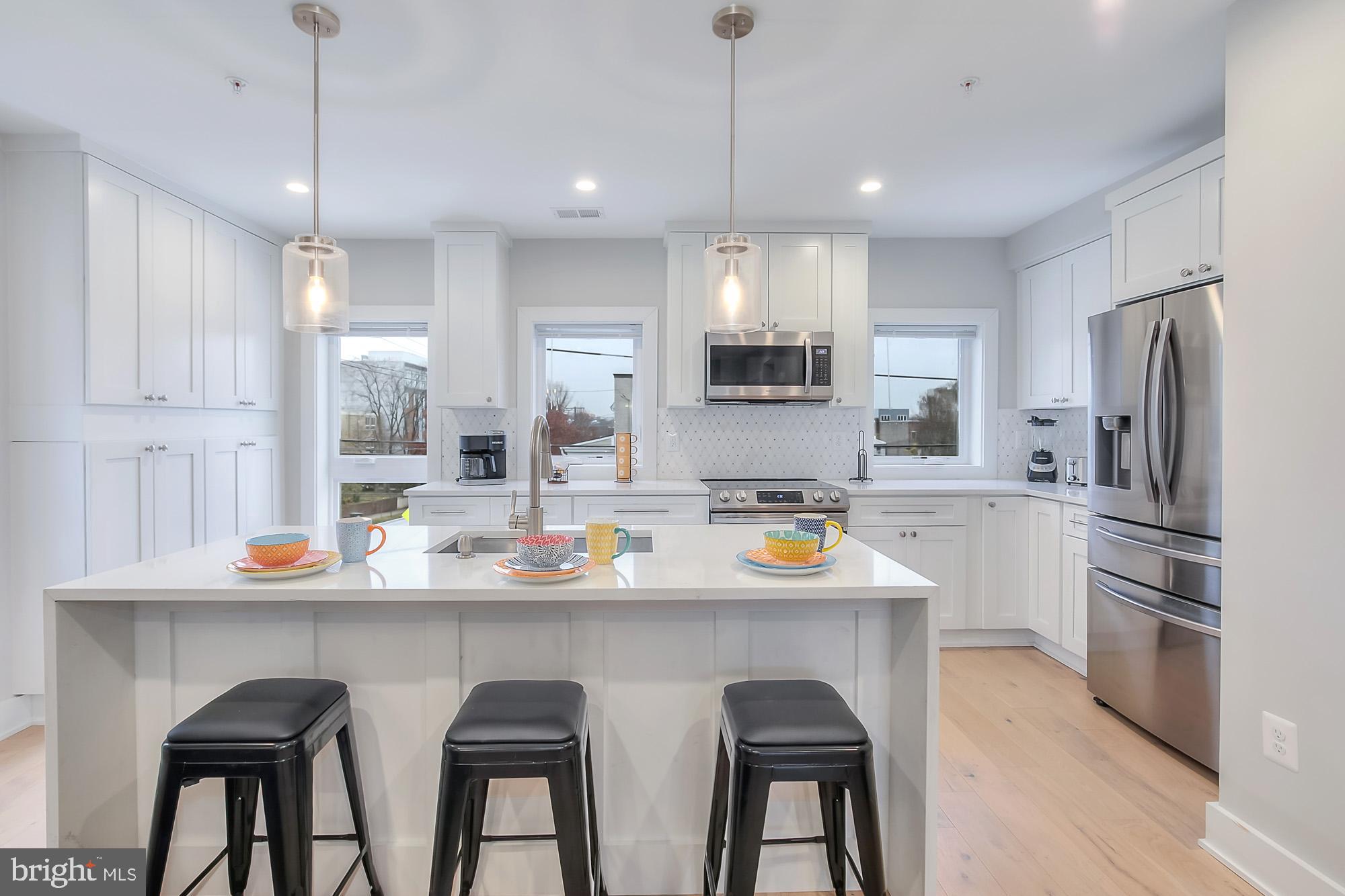 501 Longfellow Street Northwest, Unit B Washington, DC 20011 - Photo 7 of 22 a kitchen with stainless steel appliances a sink stove and refrigerator