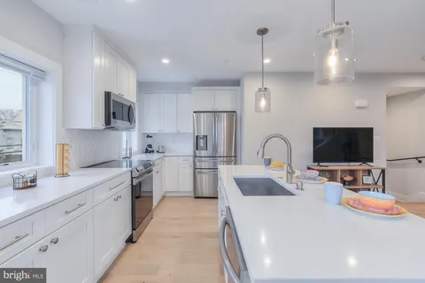 a large white kitchen with stainless steel appliances