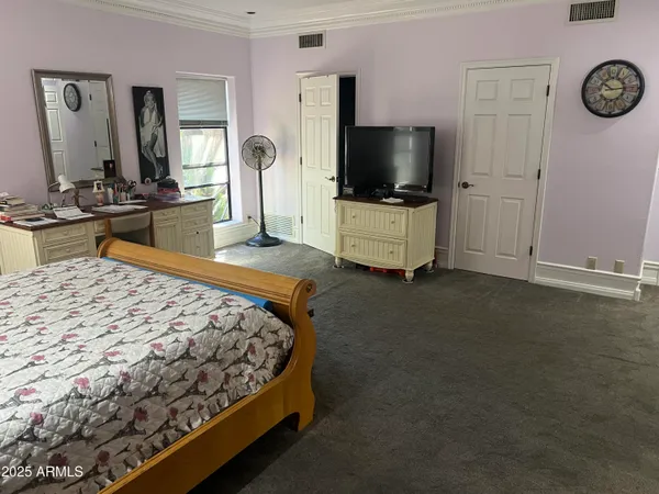 a bedroom with a bed and a flat screen tv