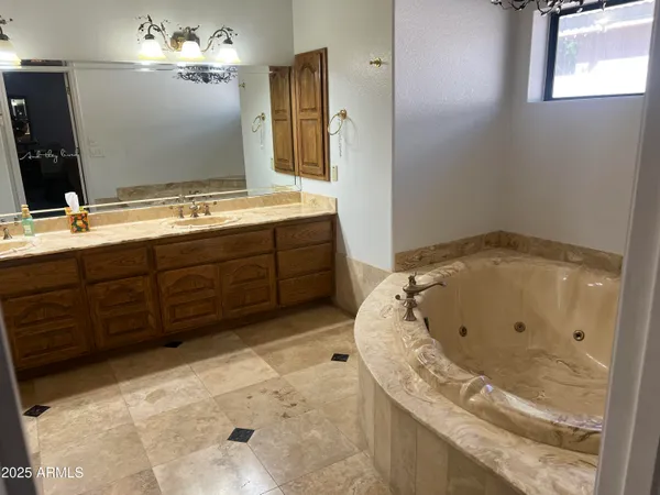a bathroom with a tub sink and mirror