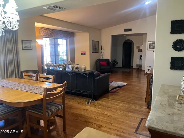a living room with furniture a dining table and chairs with wooden floor