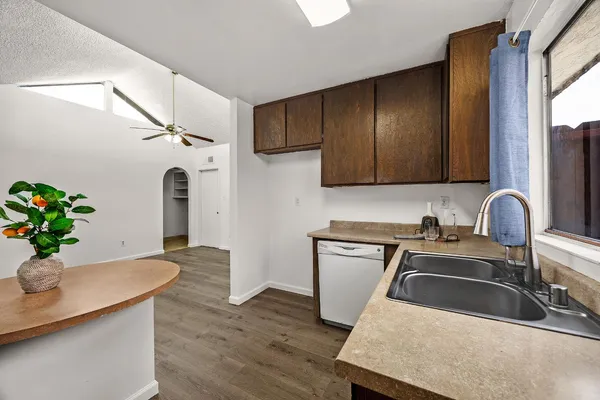 a kitchen with stainless steel appliances granite countertop a sink a stove and wooden floors