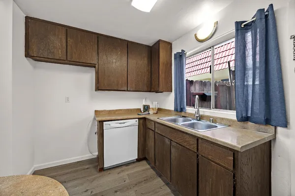 a kitchen with a sink cabinets and wooden floor