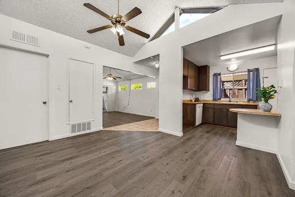 a view of a kitchen with wooden floor and a ceiling fan