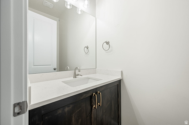 684 West High Tide Place, Unit 131 St. George, UT 84790 - Photo 7 of 27 Vanity with dark wood-finish cabinetry, brushed nickel hardware, and a white countertop featuring an integrated rectangular sink