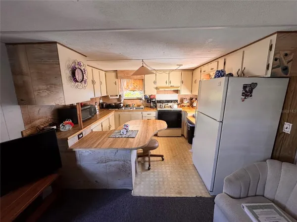 a living room with furniture and a refrigerator