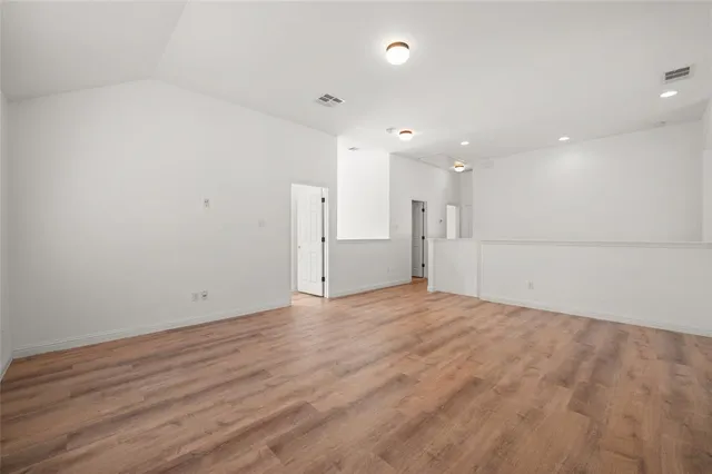 a view of empty room with wooden floor