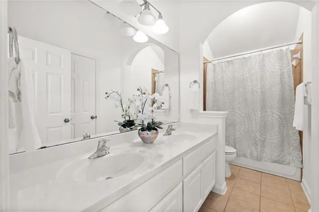 a bathroom with a double vanity sink mirror and shower