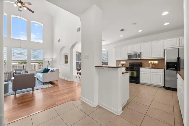 a kitchen with stainless steel appliances kitchen island granite countertop a refrigerator and microwave