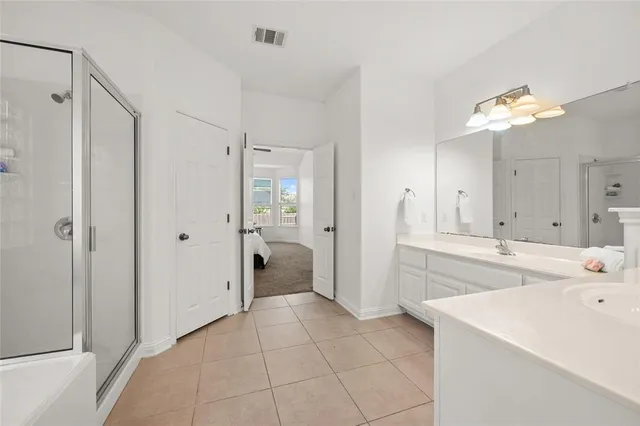 a large white kitchen with a sink and refrigerator