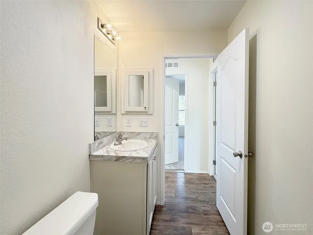 a bathroom with a granite countertop sink toilet and shower