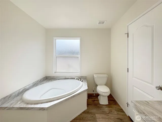 a white toilet sitting next to a bathroom sink and vanity
