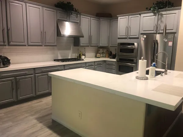 a kitchen with stainless steel appliances granite countertop a sink a stove and refrigerator