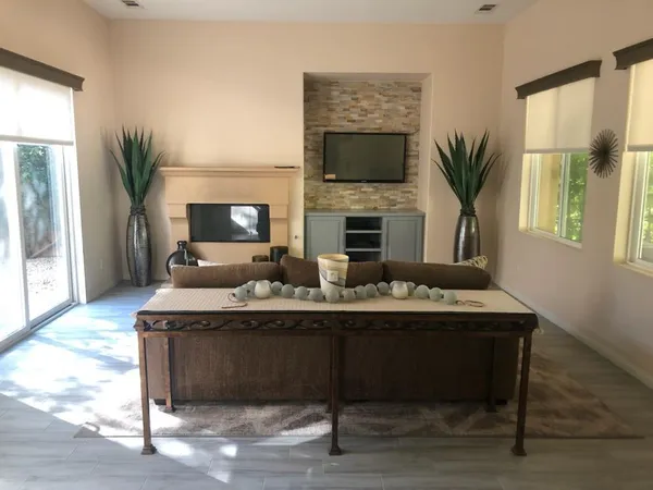 a living room with furniture a flat screen tv and a fireplace