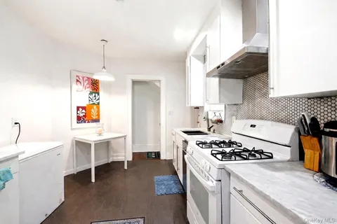 a kitchen with a stove a sink dishwasher and a stove with wooden floor