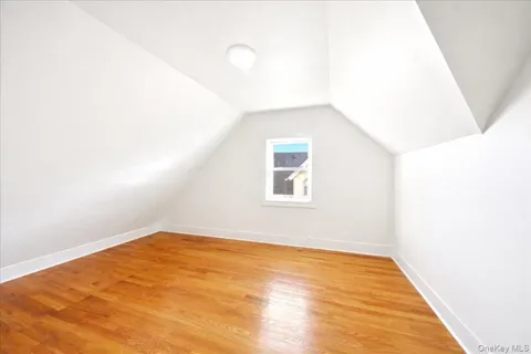 a view of a big room with wooden floor and windows
