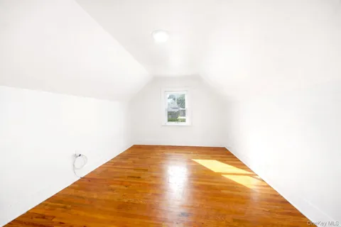 a view of a big room with wooden floor and windows