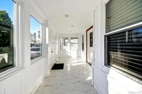 a view of a hallway with wooden floor and a living room