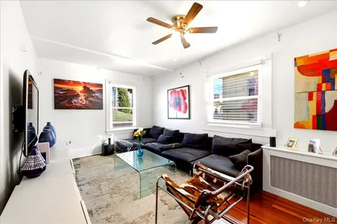 a living room with furniture a flat screen tv and a window